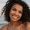 Image of beautiful happy young african woman walking at the beach outside